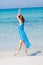 Beautiful woman in blue dress on beach in summer