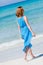 Beautiful woman in blue dress on beach in summer