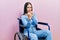 Beautiful woman with blue eyes sitting on wheelchair ready to fight with fist defense gesture, angry and upset face, afraid of