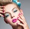 Beautiful woman with blue makeup of eyes and pink nails.