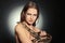 Beautiful woman with boa constrictor on dark background