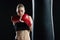 Beautiful woman is boxing on black background