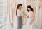 Beautiful woman bride trying on white wedding dress,Asian women tailor making adjustment on her client during fitting