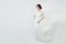 Beautiful woman bride in white lacy dress. Cute fiancee girl with blowing gown on banner background with copy space