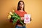 Beautiful woman celebrating mothers day holding love mom message and bouquet of tulips scared in shock with a surprise face,