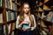 Beautiful woman choosing the book in library.