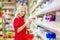 Beautiful woman choosing personal care product in supermarket