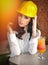 Beautiful woman civil engineer with yellow helmet taking a break in front of orange juice. Young female architect with white shirt