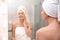 Beautiful woman with clean towels near mirror