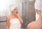 Beautiful woman with clean towels near mirror