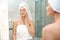 Beautiful woman with clean towels near mirror