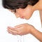 Beautiful woman cleans her face with water
