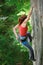 Beautiful woman climber climbing steep rock with rope