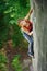 Beautiful woman climber climbing steep rock with rope