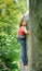 Beautiful woman climber climbing steep rock with rope