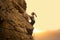 Beautiful Woman Climbing on the Rock at Foggy Sunset in the Mountains. Adventure and Extreme Sport Concept