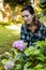 Beautiful woman crouching while looking at purple hydrangea bunch