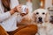 beautiful woman and cute golden retriever dog enjoying healthy breakfast at home, lying on the floor. healthy breakfast with tea,