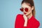 Beautiful woman in dark glasses red shirt bright makeup emotions attractive look blue background
