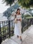 beautiful woman with dark hair in elegant clothes posing against the backdrop of the city Positano in Italy