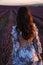 Beautiful  woman with dark hair in elegant dress with accessories posing in blooming lavender field
