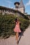 Beautiful woman with dark hair in elegant dress posing in park near antic castle