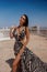 beautiful woman with dark hair in elegnt dress with zebra print posing in beach club