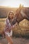 Beautiful woman with dark hair posing with horse in beautiful landscape