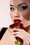 Beautiful woman with dark red roses flower in veil retro glamour