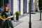 Beautiful woman in a dark stylish dress strolls along the street, near boutiques