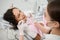 Beautiful woman in dentist`s chair during dental check-up in dentistry clinic on blurred foreground of dental hygienist holding