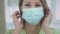 Beautiful woman doctor puts on blue medical protective mask. Protects itself from viruses during the coronavirus