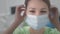 Beautiful woman doctor puts on blue medical protective mask. Protects itself from viruses during the coronavirus