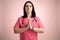 Beautiful woman doctor with stethoscope, wearing pink scrubs praying