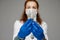 Beautiful woman doctor in white medical clothes, mask, blue gloves and phonendoscope on her shoulders, picture isolated