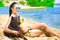 Beautiful woman and dog sitting on the beach