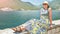 Beautiful woman in dress and hat on coast of island Boka Kotorska Montenegro