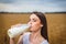 Beautiful woman drinking milk in countryside field looking at camera. close-up to very beautiful girl with amazing green eyes and