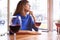 Beautiful woman drinking red wine with friends in cafe, portrait with wine glass near window. Vocation holidays bar concept