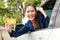 Beautiful woman driving a car parked on the side of the road Smiling happy holding a credit card to pay for car repairs.