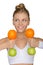 Beautiful woman with dumbbells fruits looking away