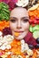 Beautiful woman eating organic fruits and vegetables chips on colorful chips background. Healthy snack eating