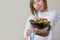 Beautiful woman eating salad with fork tape measure wrapped.