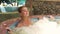 Beautiful woman enjoying jacuzzi bath on spa center. Portrait young woman relaxing in jacuzzi tub while resting in