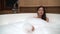 Beautiful Woman enjoying relaxing bubble bath lifestyle real natural body care