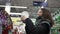 Beautiful woman examines a Christmas glass ball in a supermarket