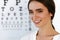 Beautiful Woman With Eye Test Chart At Ophthalmology Office