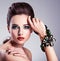 Beautiful woman face with fashion green make-up and jewelry on h
