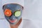 Beautiful woman with a face mask with cucumbers and tomatoes on the eye