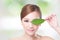 Beautiful woman face portrait with green leaf